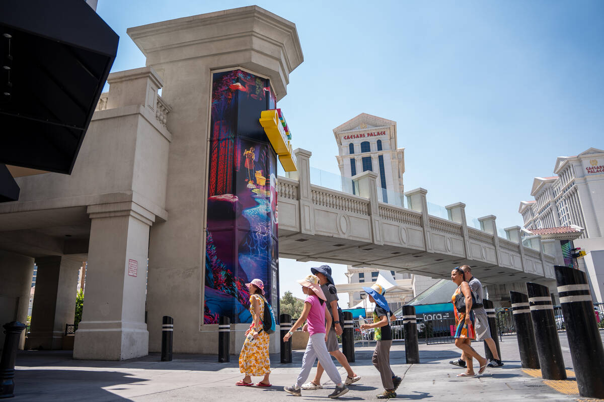 Pedestrians pass by the elevator towers along The Strip on Aug. 5, 2025 in Las Vegas. (Kara Gil ...