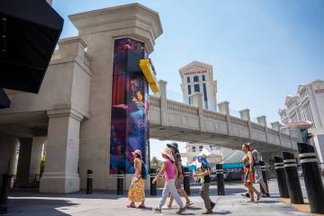 Pedestrians pass by the elevator towers along The Strip on Aug. 5, 2025 in Las Vegas. (Kara Gil ...