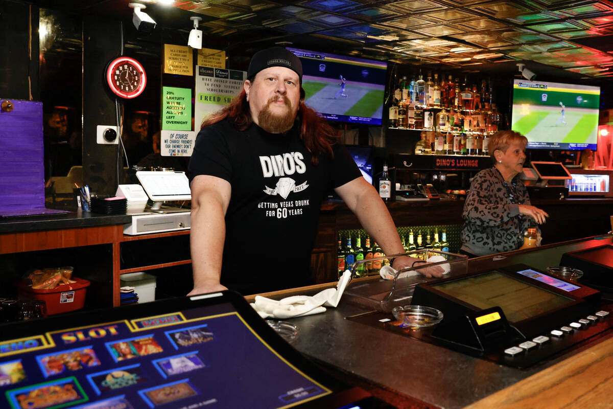 Erik Rensch, a bartender at Dino’s Lounge, poses for a photo behind a counter on Thursda ...