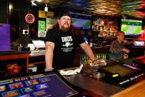 Erik Rensch, a bartender at Dino’s Lounge, poses for a photo behind a counter on Thursda ...