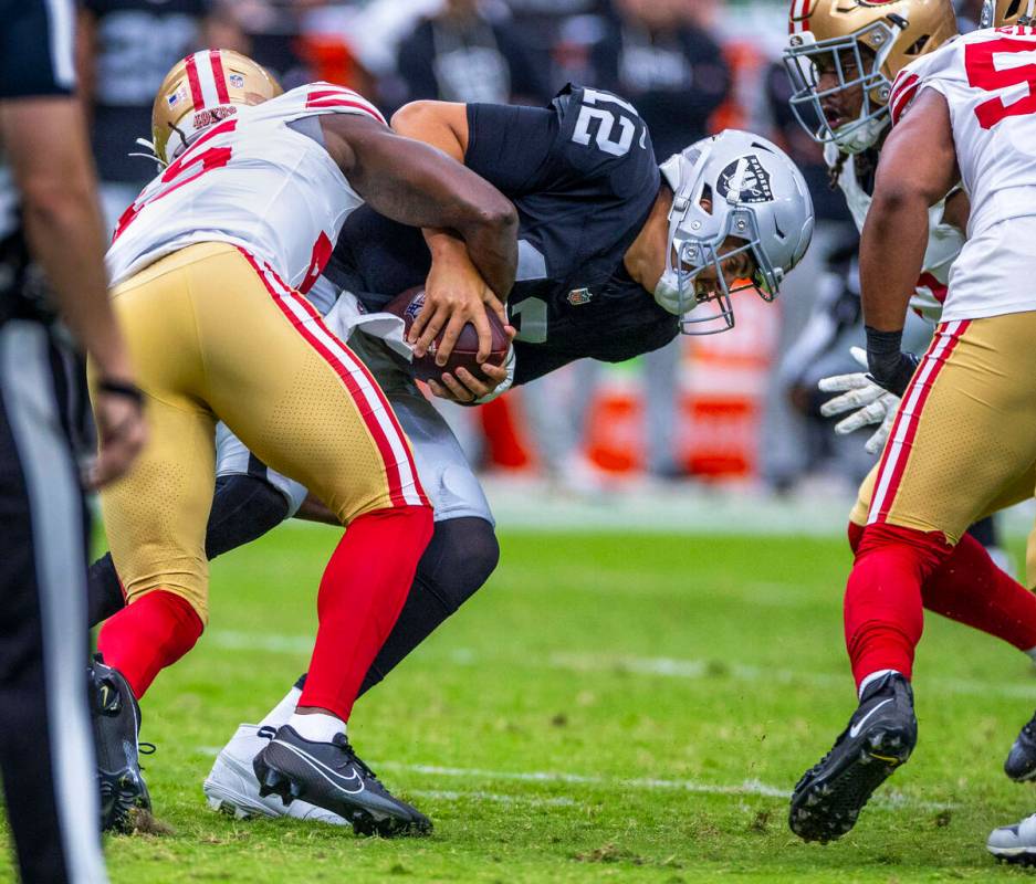Raiders quarterback Aidan O'Connell (12) is sacked by San Francisco 49ers linebacker Nick Marti ...