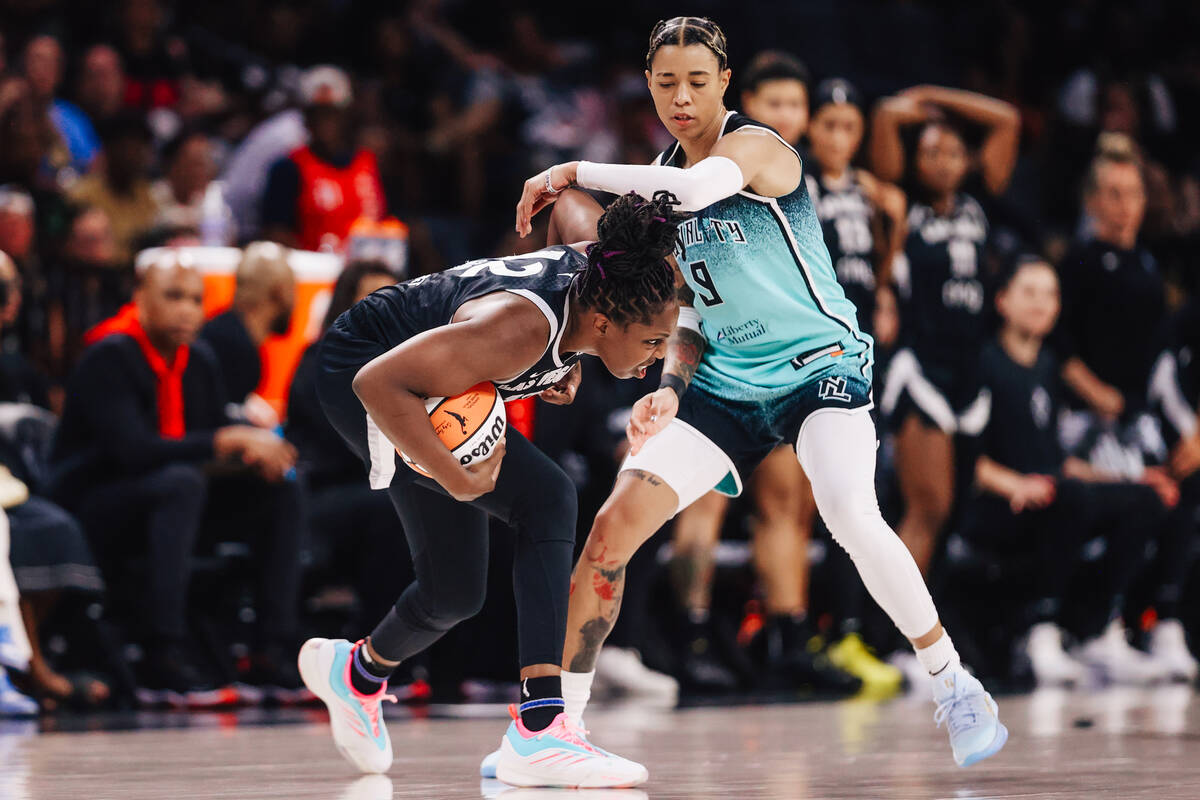 Aces guard Chelsea Gray (12) ducks to avoid defense by New York Liberty guard Natasha Cloud (9) ...