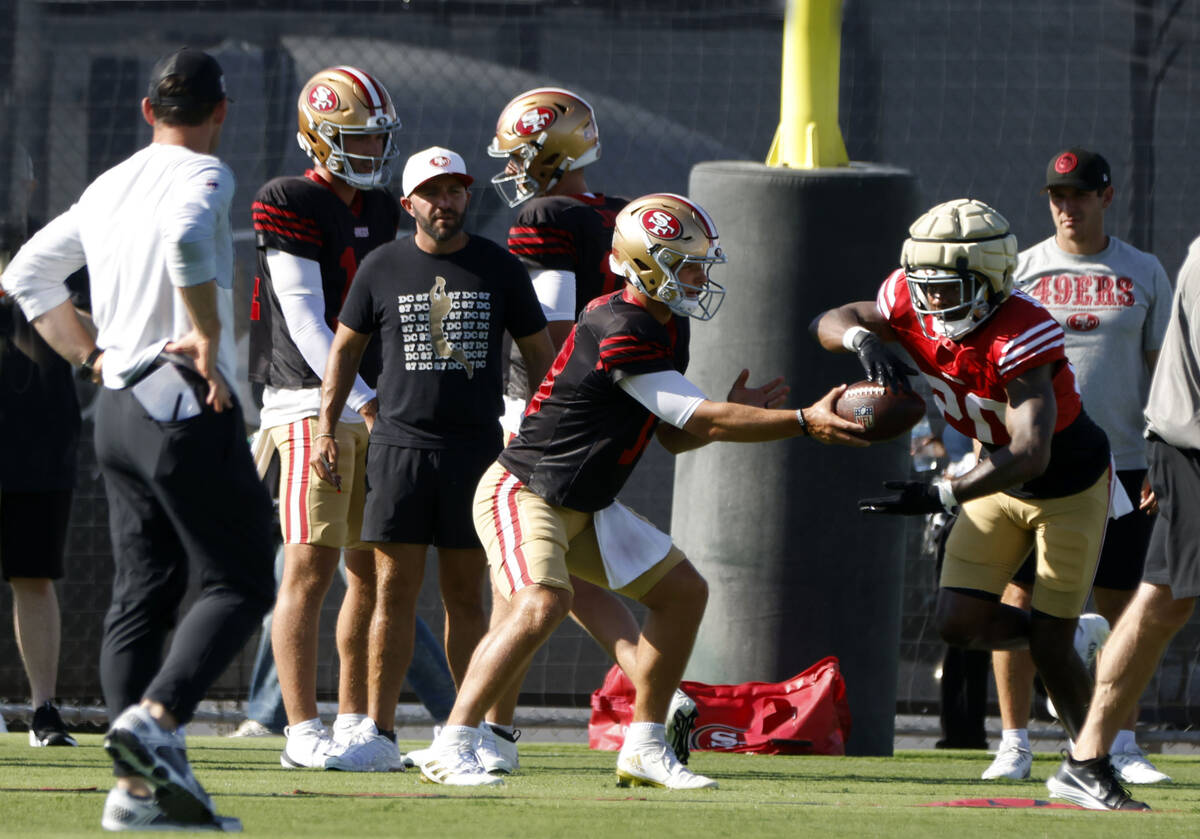 San Francisco 49ers quarterback Brock Purdy, left, hands the ball to cornerback Upton Stout dur ...
