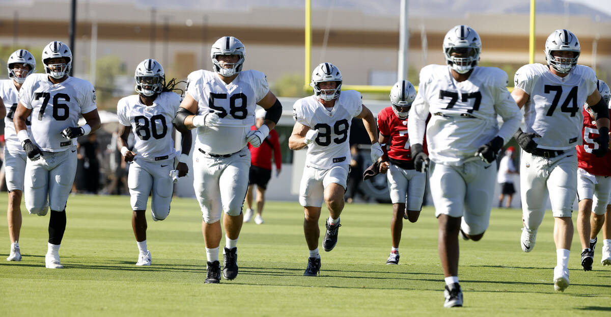 Raiders offensive tackle Caleb Rogers (76) tight end Ian Thomas (80) center Jackson Powers-John ...