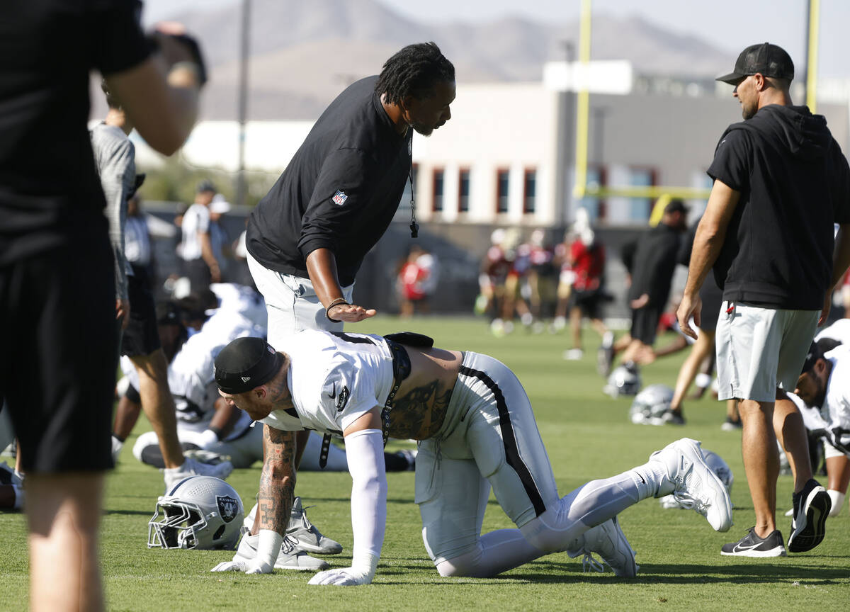Raiders defensive coordinator Patrick Graham taps the shoulder of defensive end Maxx Crosby (98 ...