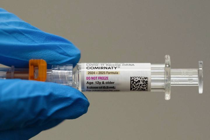 FILE - A pharmacist holds a Pfizer and BioNTech COVID-19 vaccine shot on Thursday, April 24, 20 ...