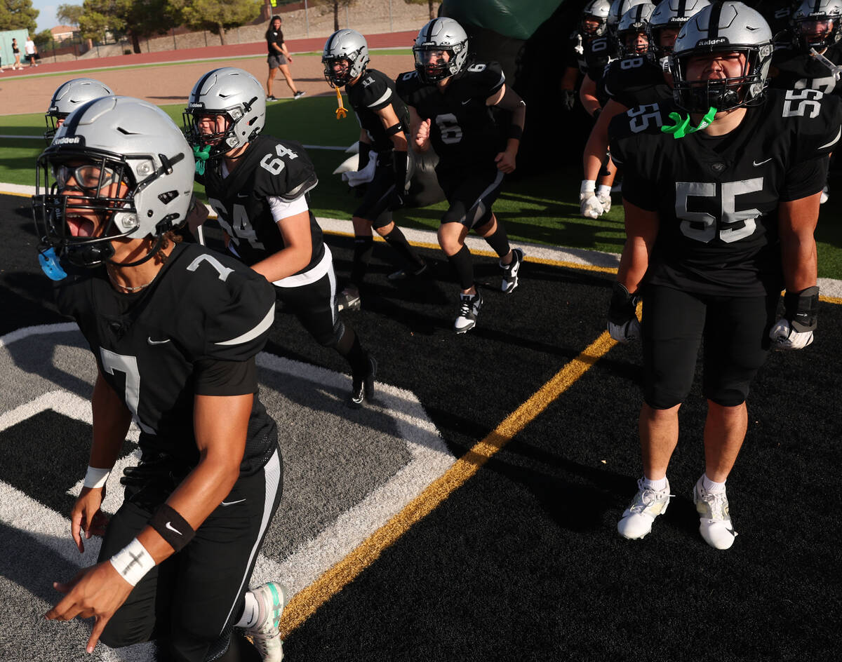 Palo Verde outside linebacker De' Anthony Thompson (7), left, takes the field with his teammate ...