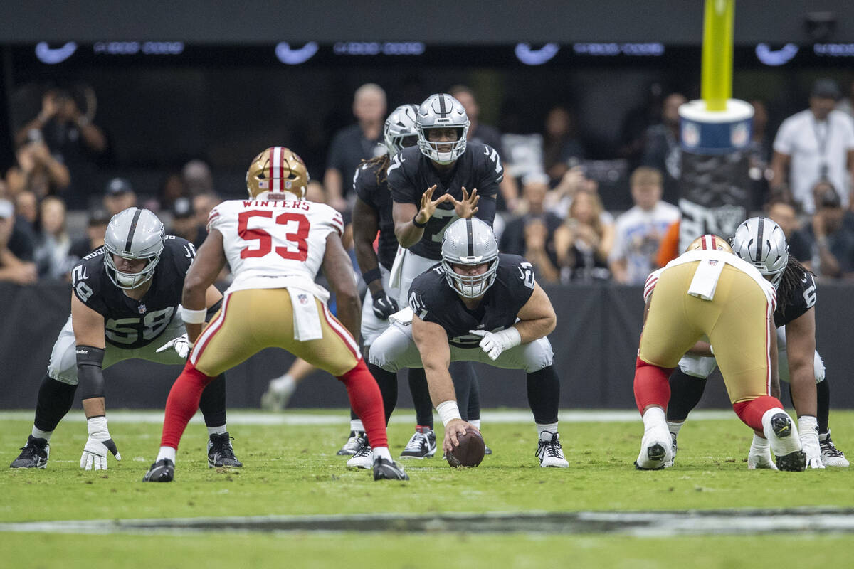 Raiders quarterback Geno Smith (7) waits for the snap from center Jordan Meredith (61), who is ...