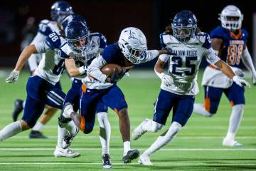 Legacy halfback Zaione Henderson (5) is grabbed from behind by Shadow Ridge safety Hawkin Ledin ...