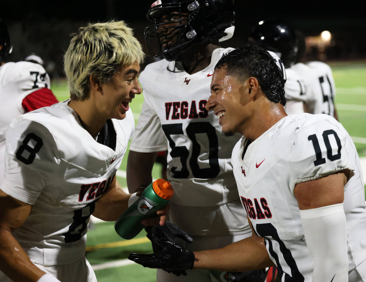 Las Vegas quarterback Tanner Vibabul (8) celebrates with teammate Chris Fernandez (10) after Fe ...