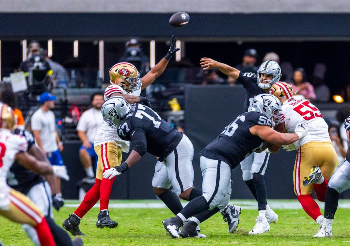Raiders quarterback Aidan O'Connell (12) gets off a pass against the San Francisco 49ers during ...