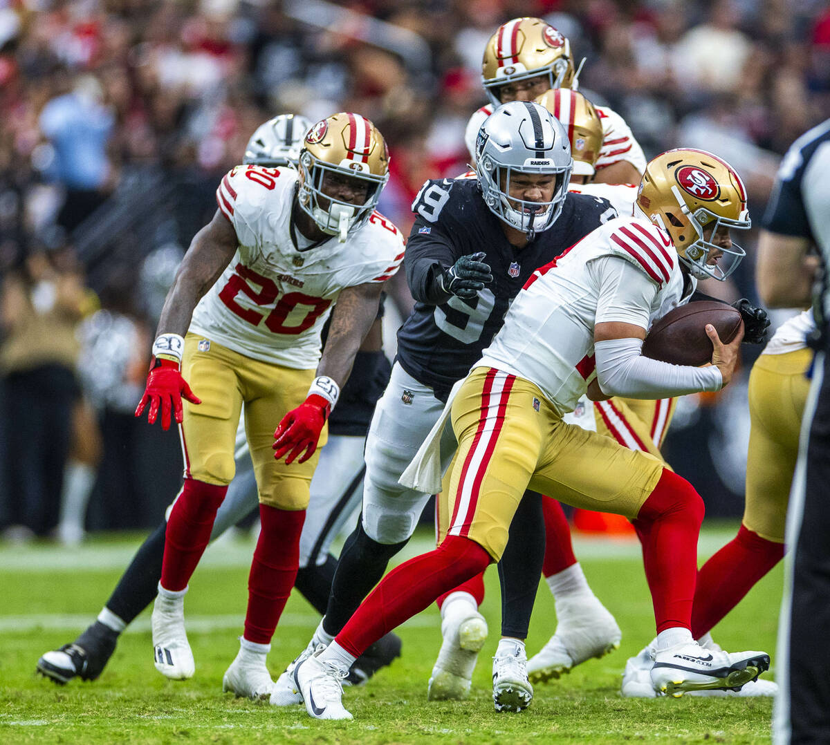 San Francisco 49ers quarterback Carter Bradley (14) sacked by Raiders defensive end Andre Carte ...