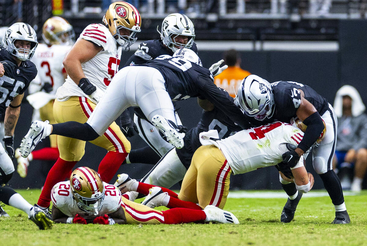San Francisco 49ers quarterback Carter Bradley (14) sacked by Raiders linebacker Michael Barret ...