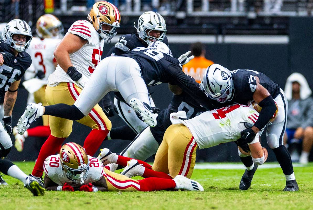 San Francisco 49ers quarterback Carter Bradley (14) sacked by Raiders linebacker Michael Barret ...