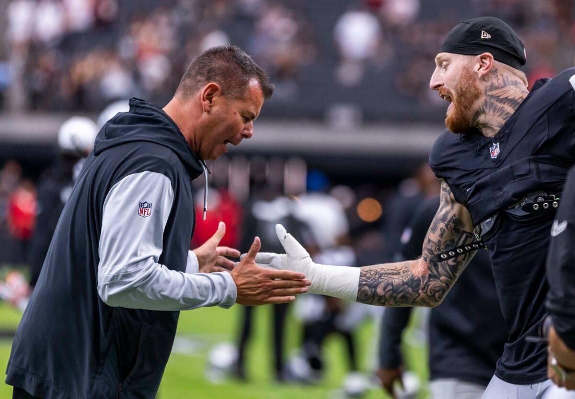 Raiders tight end Brock Bowers (89) slaps hands with a coach during warm ups of their pre-seaso ...