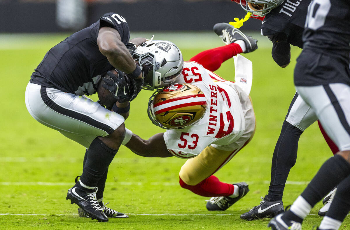 Raiders running back Ashton Jeanty (2) works to shake off a tackle attempt by San Francisco 49e ...