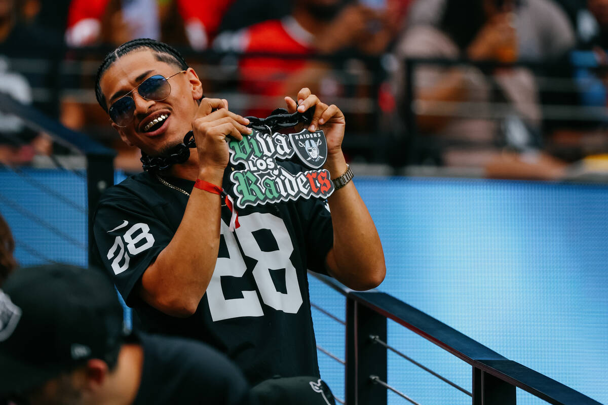 A fan holds up a “viva los Raiders” necklace during the first half of the game on ...