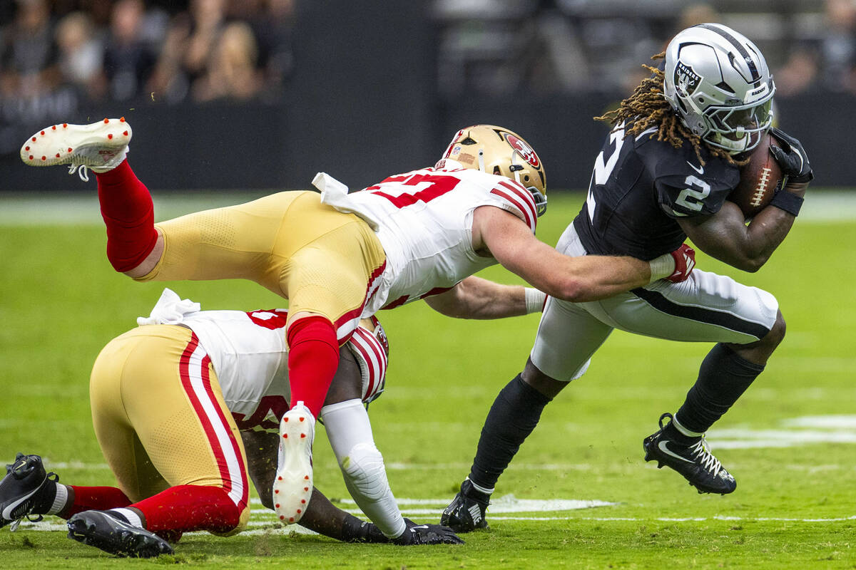 Raiders running back Ashton Jeanty (2) looks to shake off a tackle attempt by San Francisco 49e ...