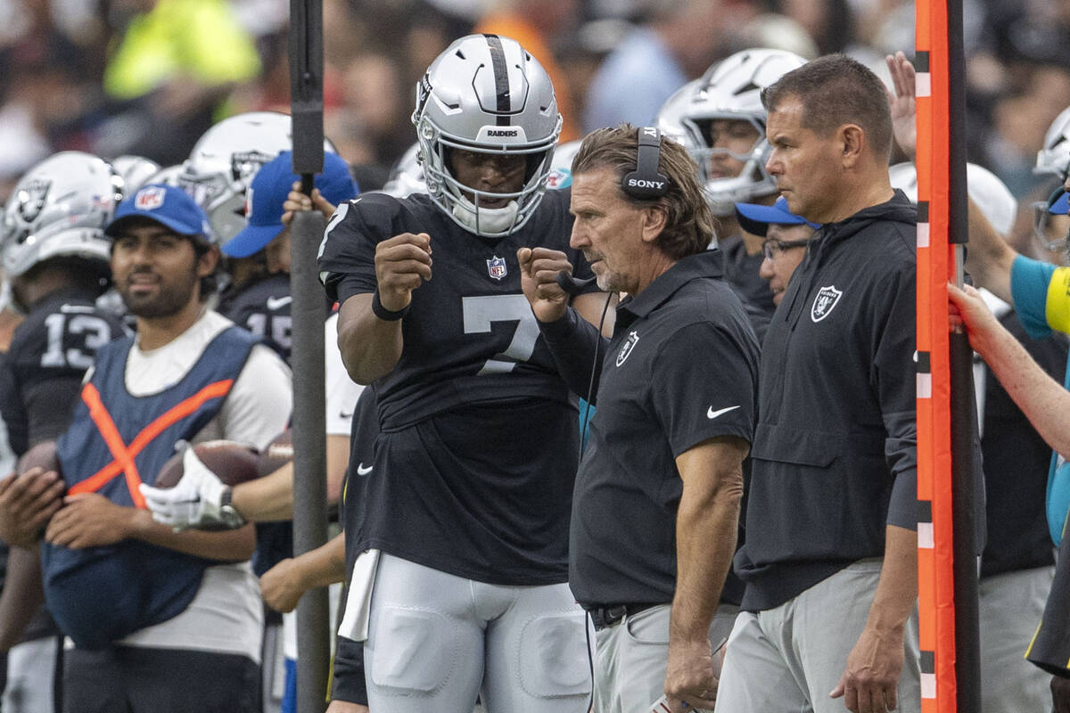 Raiders quarterback Geno Smith (7) speaks with quarterbacks coach Greg Olson during the first h ...