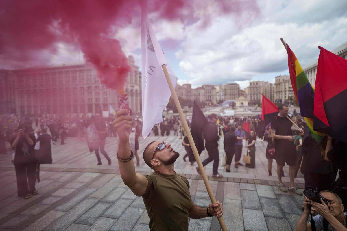 A man holds color smoke during the farewell ceremony of David Chichkan, a Ukrainian serviceman ...