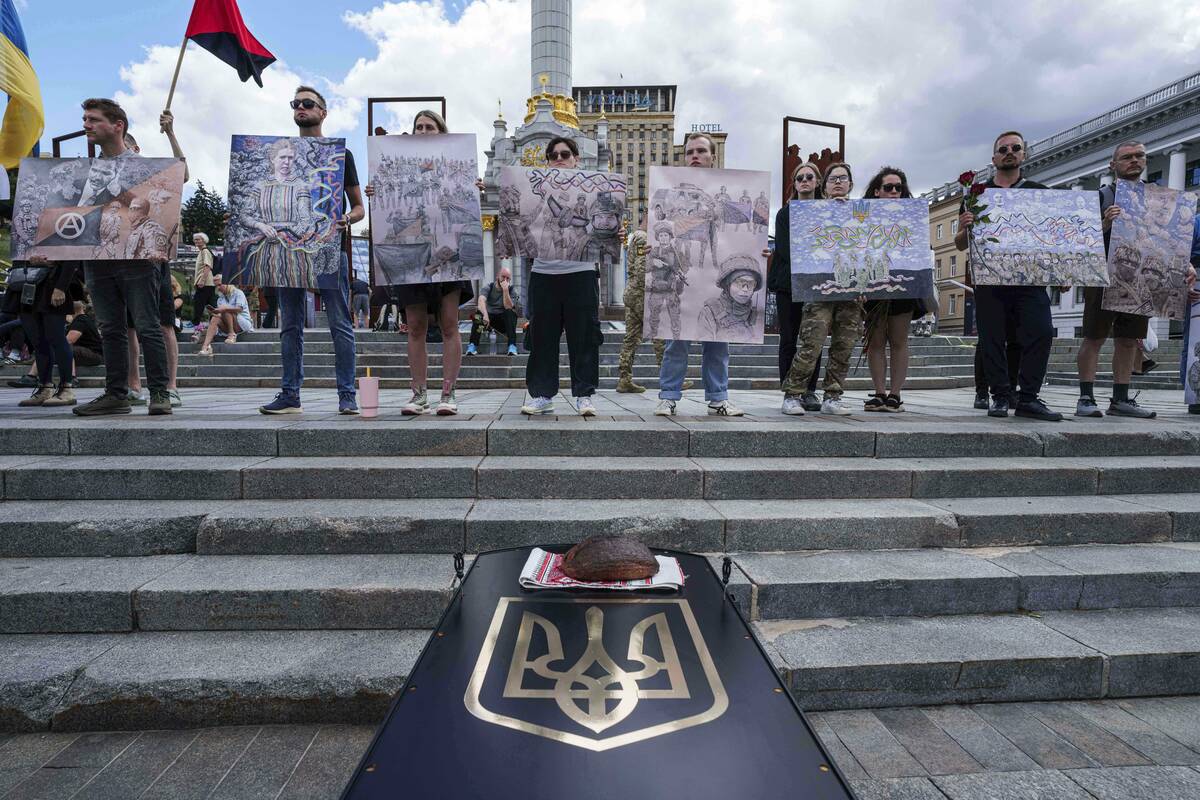 People hold works of David Chichkan, a Ukrainian serviceman and artist during his farewell cere ...