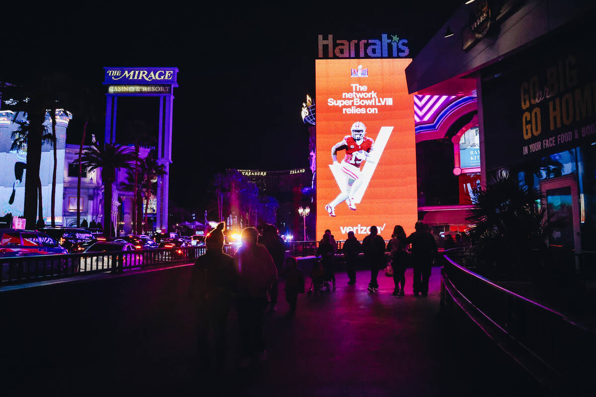 Tourists walk by a Verizon Super Bowl ad near Harrah’s on Friday, Feb. 9, 2024, in Las V ...