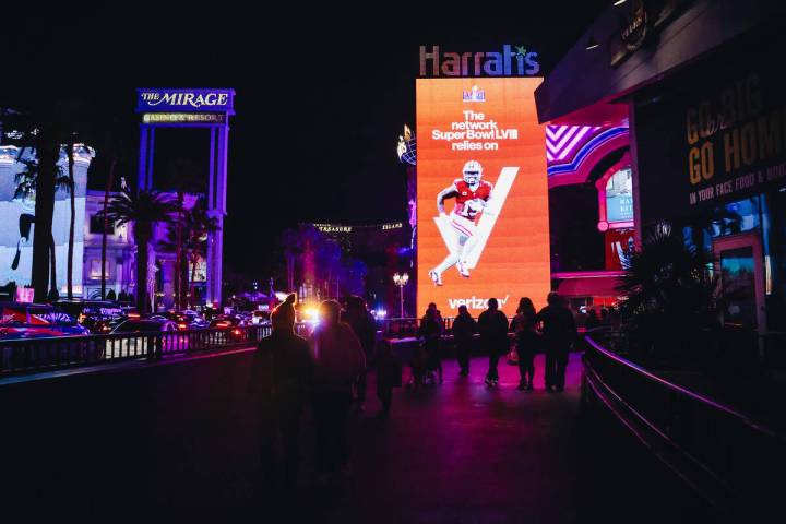 Tourists walk by a Verizon Super Bowl ad near Harrah’s on Friday, Feb. 9, 2024, in Las V ...
