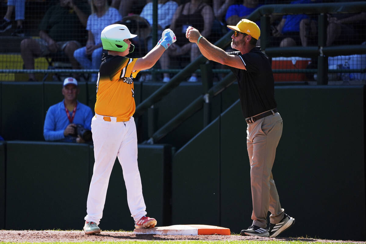 Irmo, S.C.'s Brayden Gerard, left, celebrates with coach Pat Gravelle, right, during the t ...