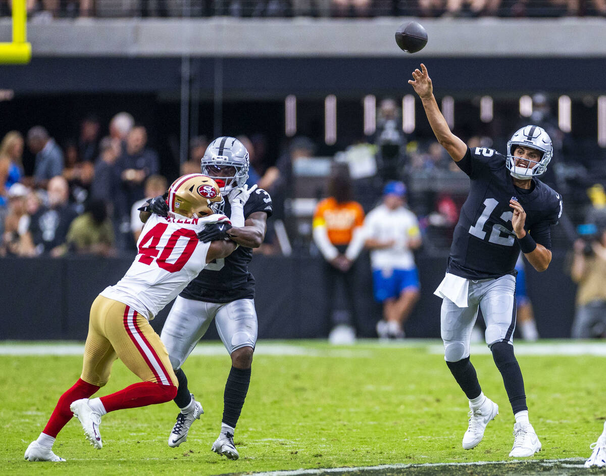Raiders quarterback Aidan O'Connell (12) gets off a pass against the San Francisco 49ers during ...