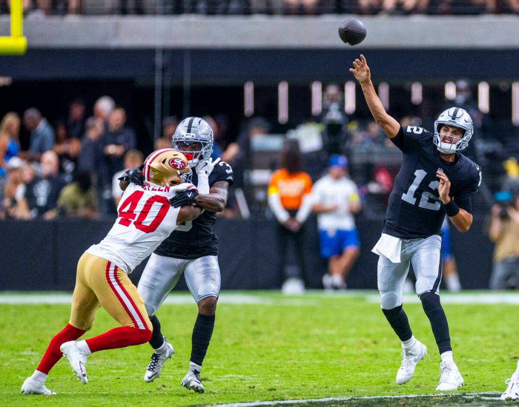 Raiders quarterback Aidan O'Connell (12) gets off a pass against the San Francisco 49ers during ...
