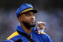 FILE - Seattle Mariners' Víctor Robles looks to the field from the dugout with a miniature ...