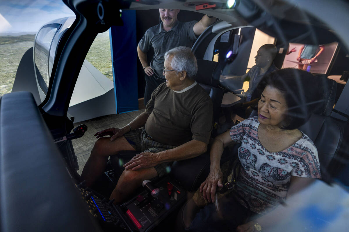 Flight instructor Phil Starcher, top, talks Dan Dee through a flight demo as his wife Lily join ...