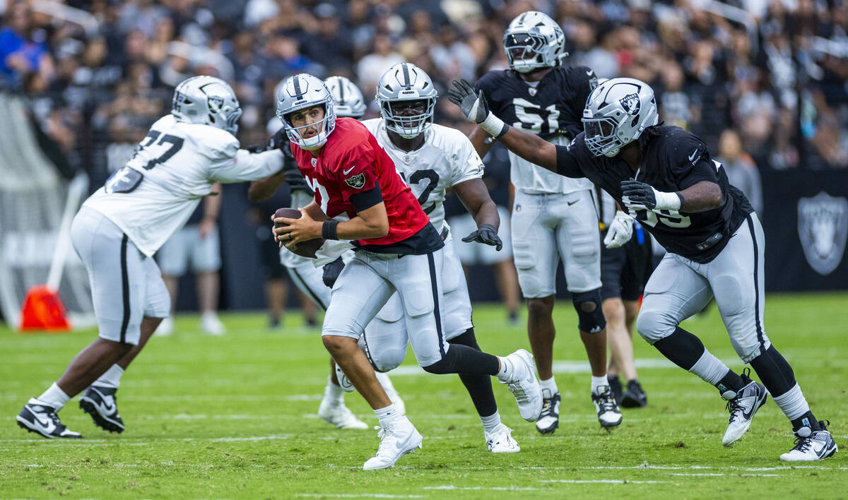 Raiders quarterback Aidan O'Connell (12) takes off for a run as Raiders defensive tackle Adam B ...