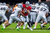 Raiders running back Zamir White (3) takes a handoff from quarterback Aidan O'Connell (12) duri ...