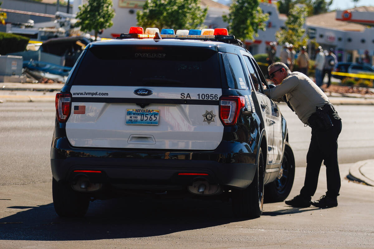 A police officer stands at a scene after a crash on Buffalo and Vegas Drive Thursday, July 31, ...