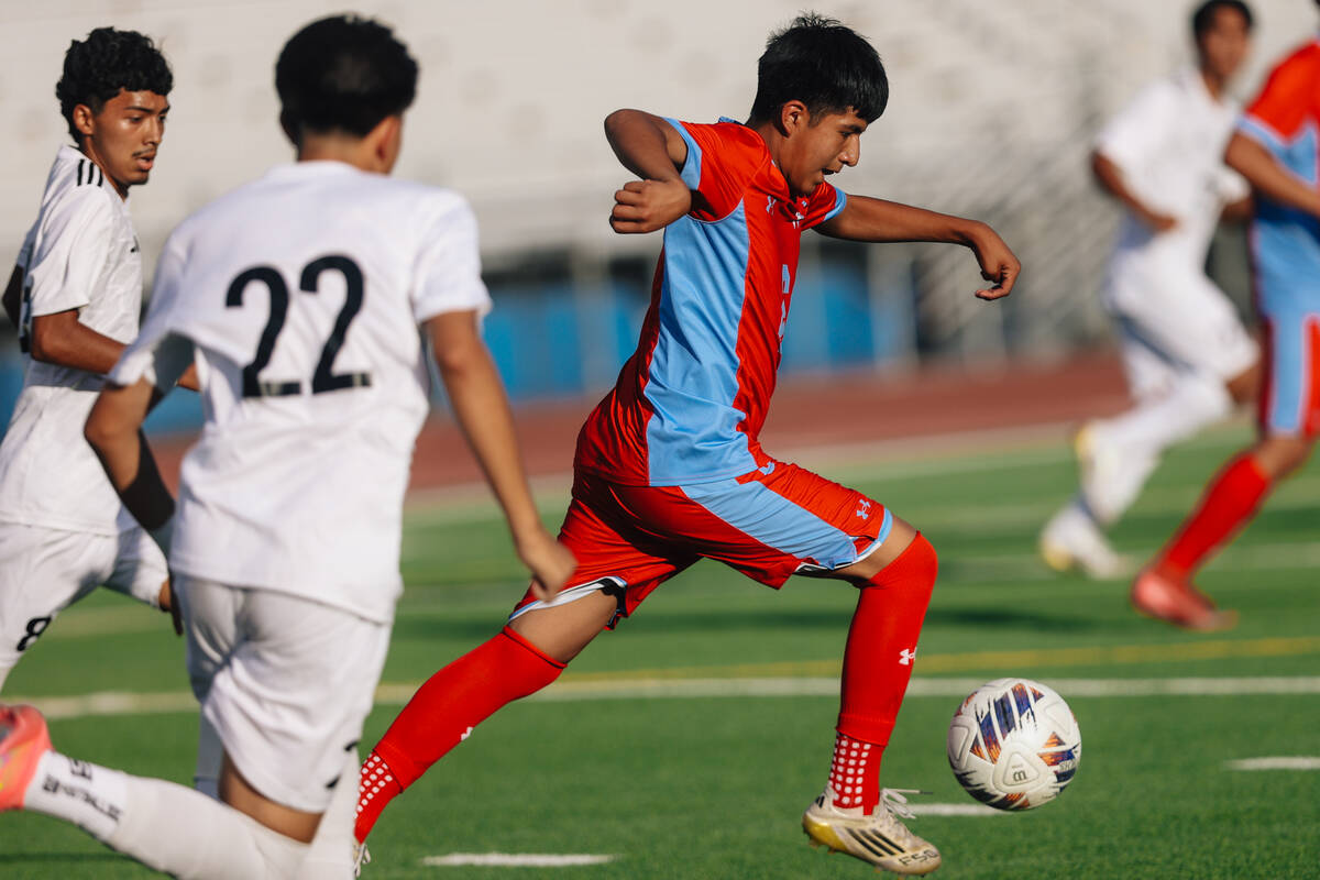 A Western soccer play chases the ball during a high school boys soccer game between Western and ...