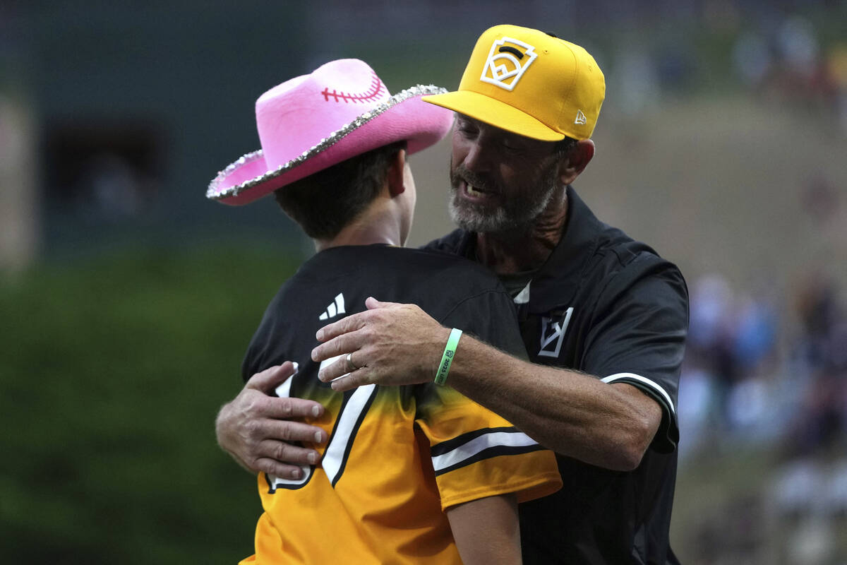 Irmo, S.C.'s Brody Miller, left, and coach Pat Gravelle, right, hug during the second inning of ...
