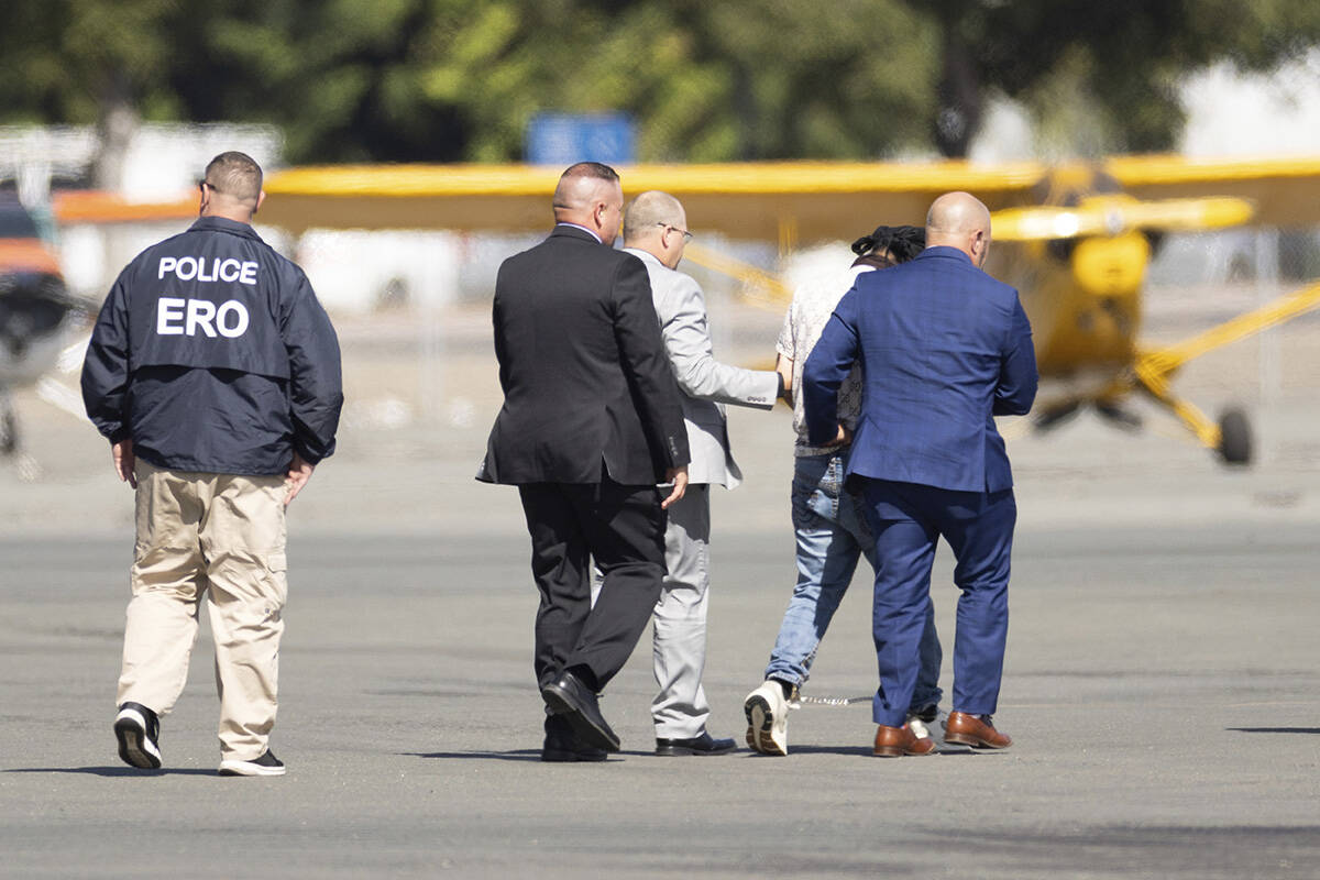 Harjinder Singh is escorted to an airplane by Florida Lt. Gov. Jay Collins and law enforcement ...