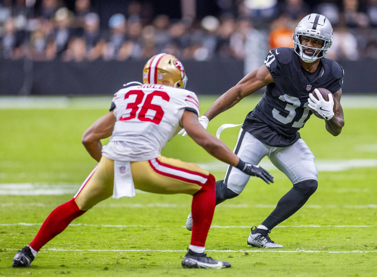 Raiders running back Raheem Mostert (31) looks to move around San Francisco 49ers safety Marque ...