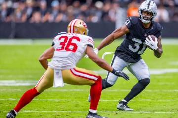 Raiders running back Raheem Mostert (31) looks to move around San Francisco 49ers safety Marque ...