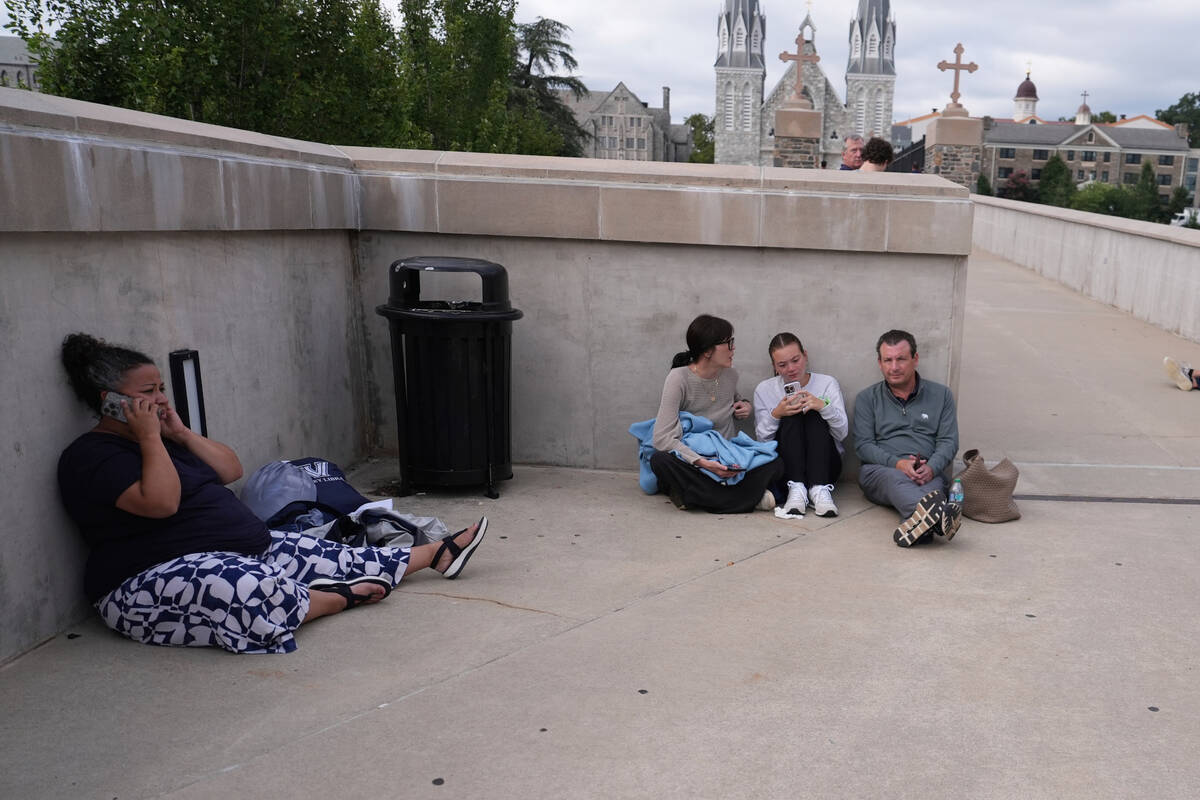 CORECTS TO PEOPLE, NOT POLICE - People shelter behind a wall on the Villanova University campus ...