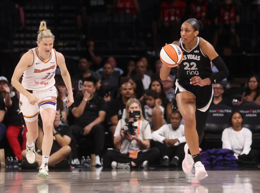 Aces center A'ja Wilson (22) brings the ball up court past Phoenix Mercury guard Sami Whitcomb ...