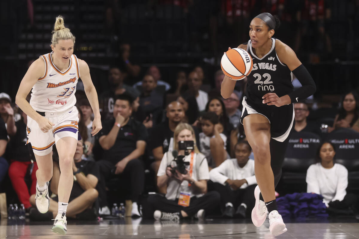Aces center A'ja Wilson (22) brings the ball up court past Phoenix Mercury guard Sami Whitcomb ...