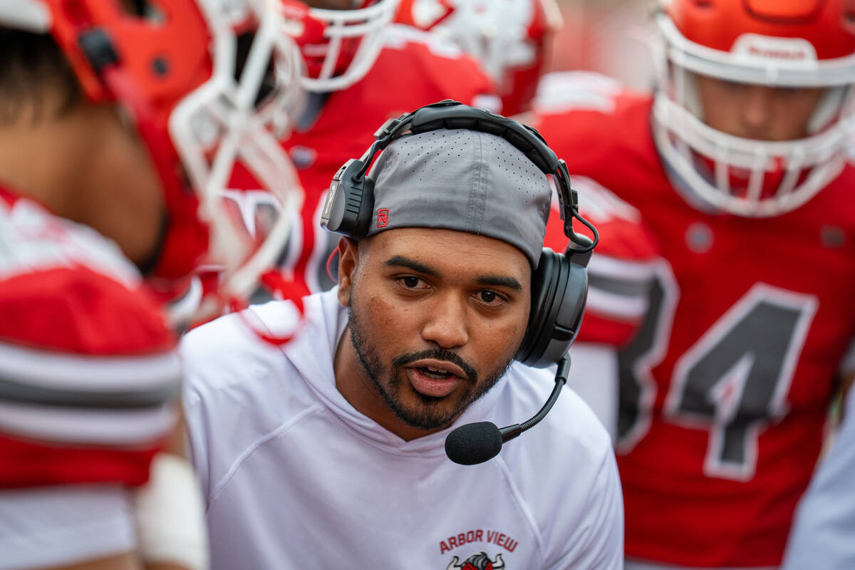 Arbor View discusses strategies during a timeout at a football game between Mililani and Arbor ...