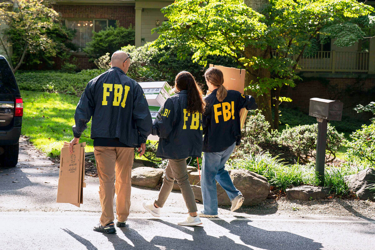 FBI agents carry empty boxes to former national security adviser John Bolton's house, Friday, A ...