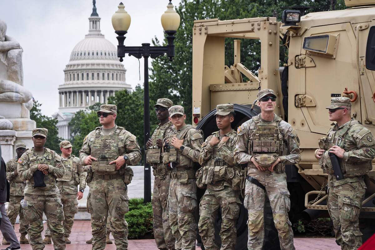 Protesters, police, and National Guard troops congregate at the entrance to Union Station in Wa ...