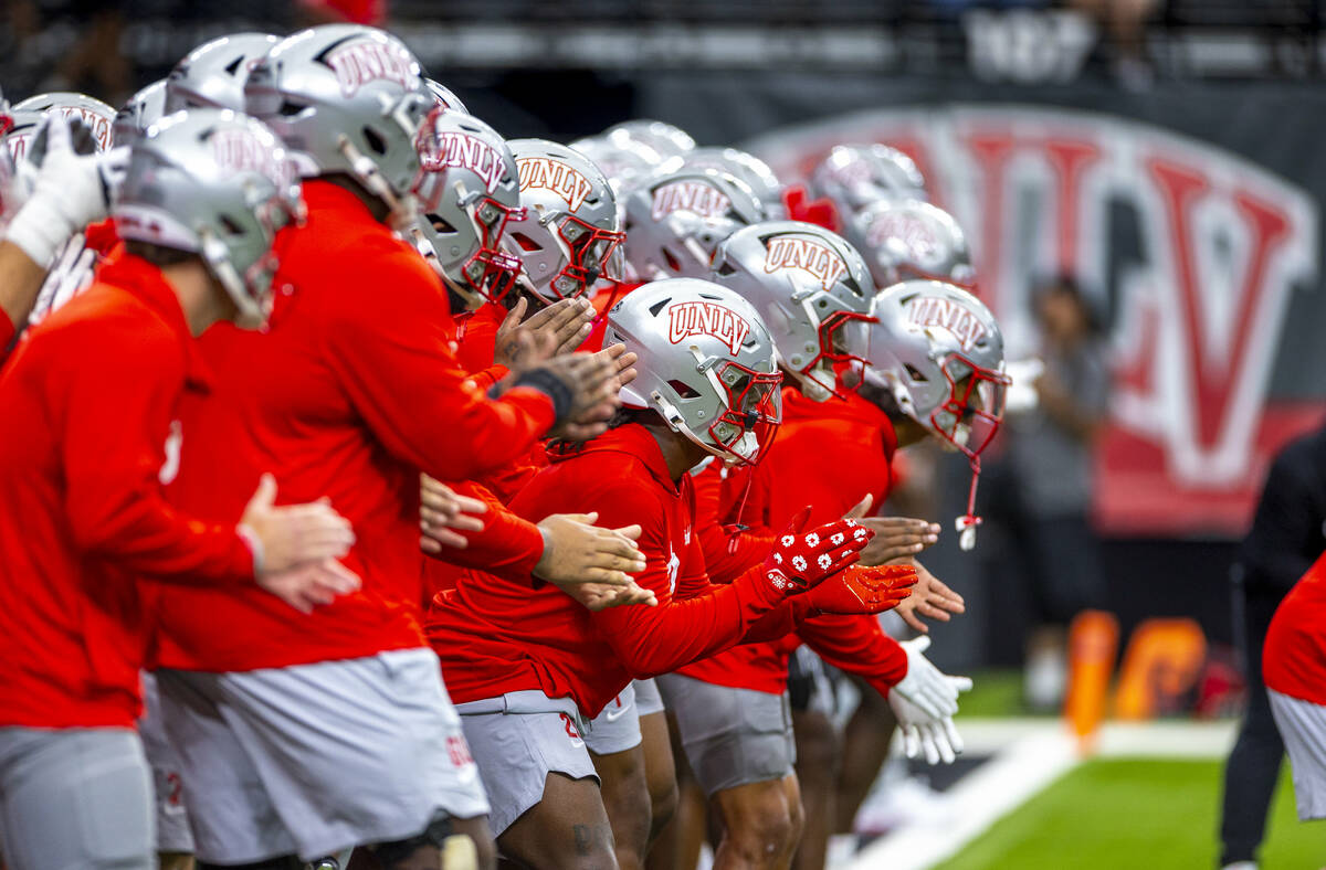 UNLV players get pumped up during warm ups before the first half of their NCAA football season- ...