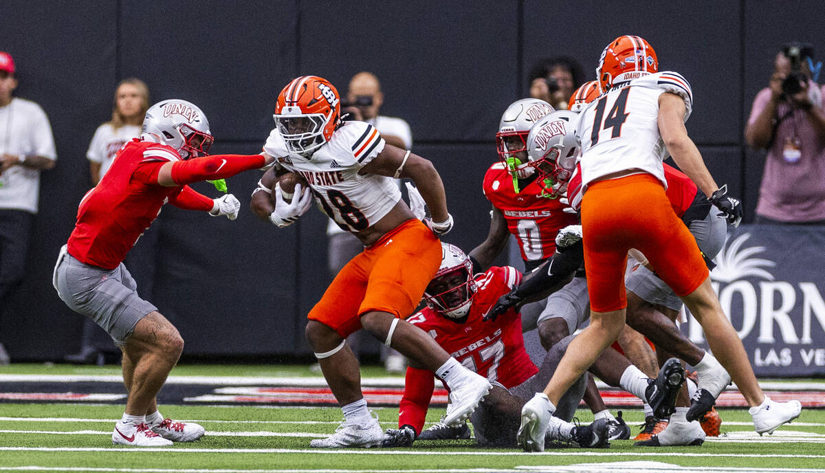 Idaho State Bengals running back Dason Brooks (28) is spun around as UNLV defenders attempt to ...