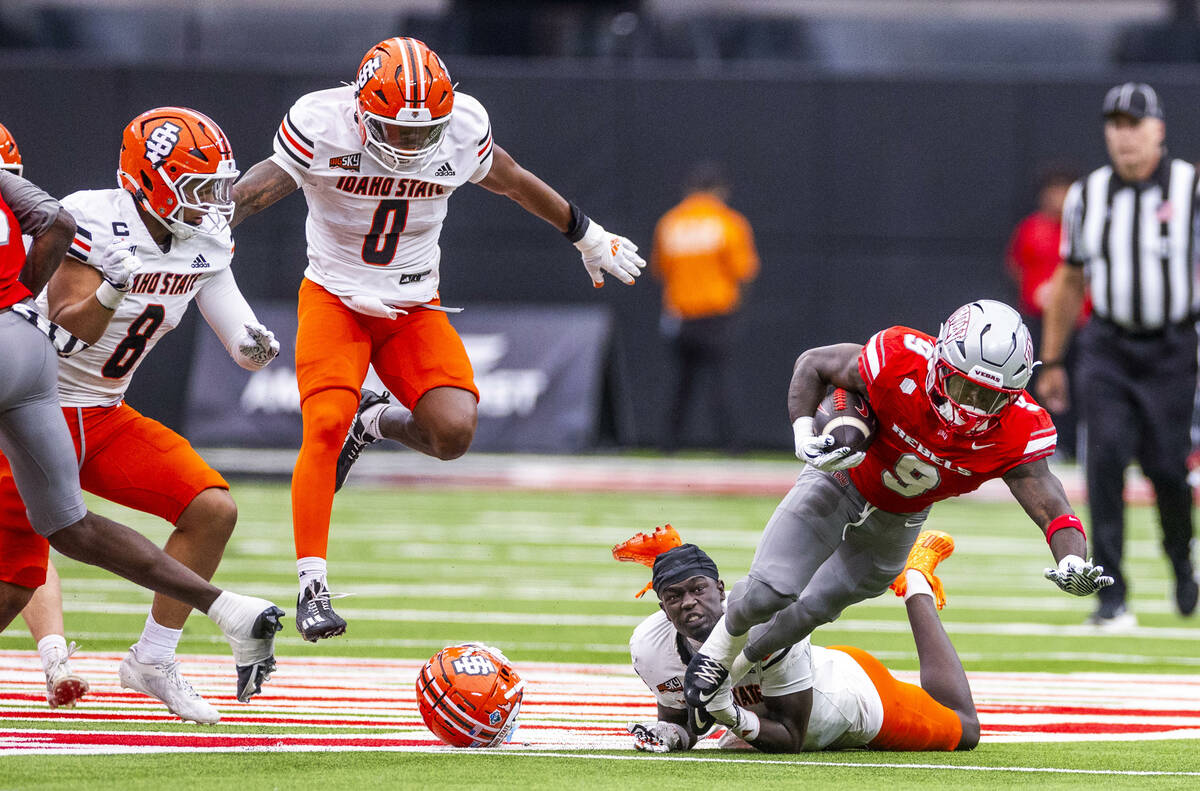 UNLV running back Jai'Den Thomas (9) is tripped up by Idaho State Bengals cornerback Gabe Tahir ...