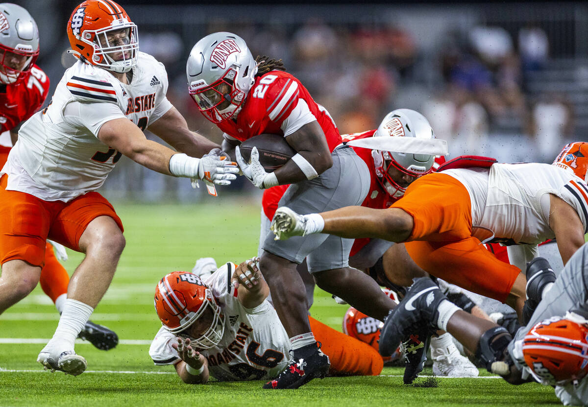 UNLV running back Jaylon Glover (20) blasts his way through the line as Idaho State Bengals def ...